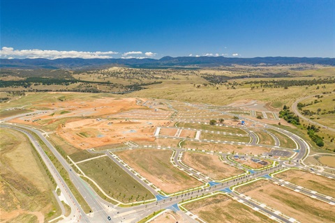 An aerial photograph of a new subdivision with freshly paved roads, no buildings.