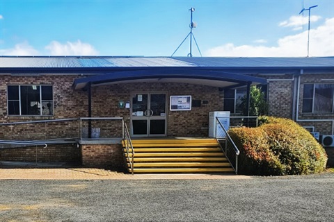 A single-storey brick veneer building with stairs and an accessible entrance ramp.