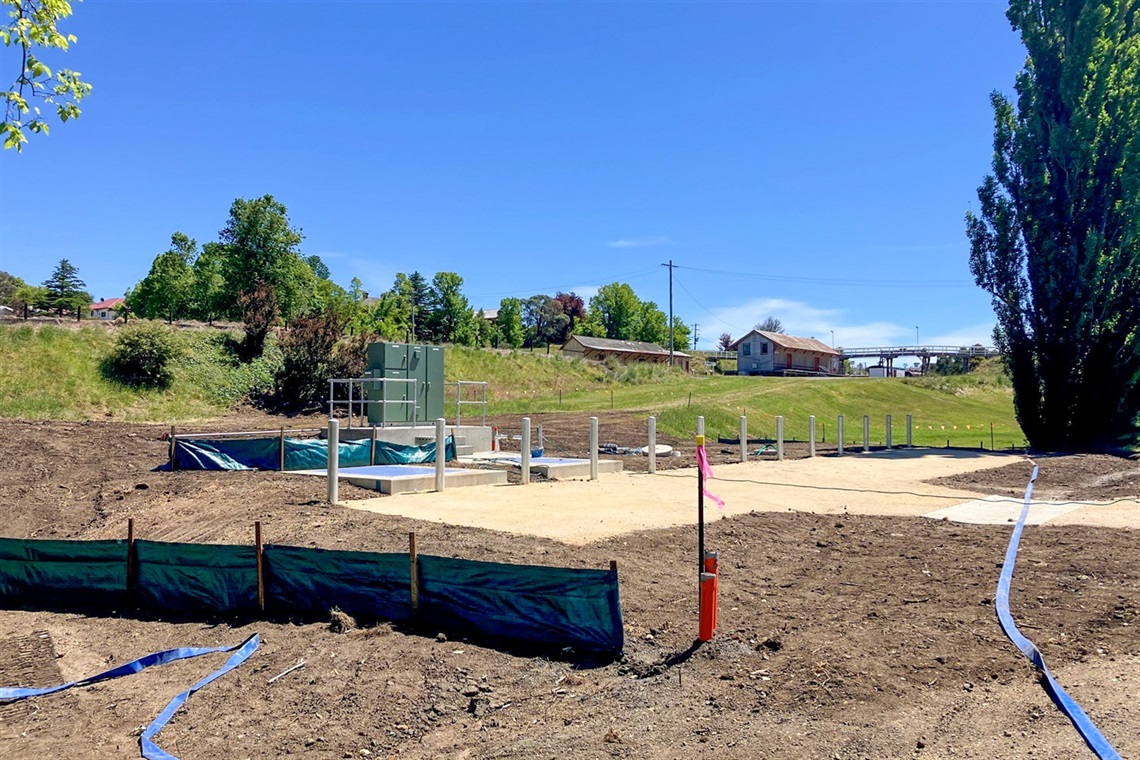 Earthworks, site fencing, and new construction on-site at the new Bombala Sewage Pumping Station, green grass and poplar trees surrounding Earthworks, site fencing, and new construction on-site at the new Bombala Sewage Pumping Station, green grass and poplar trees surrounding