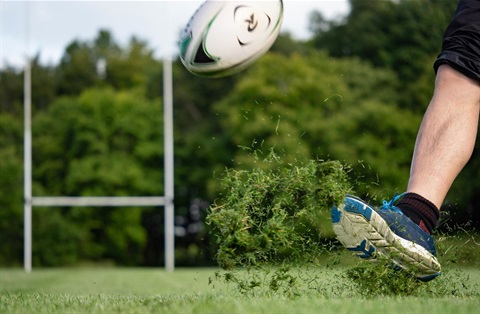 Close-up of rugby ball being kicked on oval.jpg