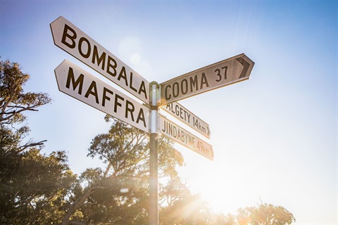Road sign at corner of Maffra Road and The Snowy River Way, pointing to Bombala, Cooma and Jindabyne
