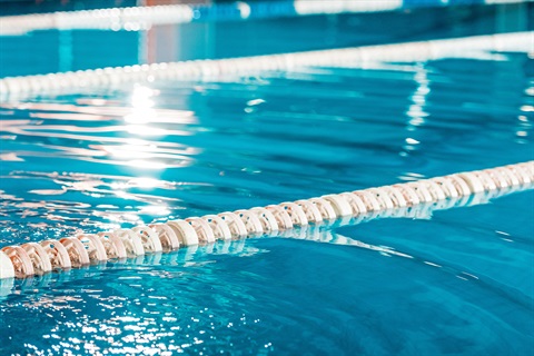 Close-up of water's surface and lane ropes at a public swimming pool