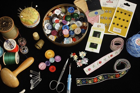 Hand-sewing material laid out against a black background