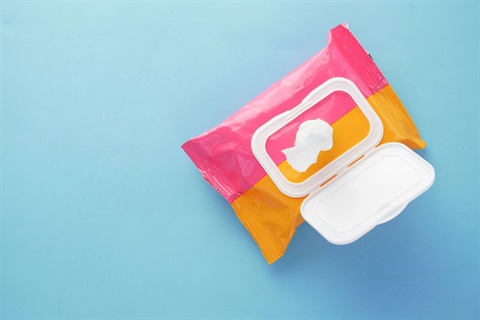 A packet of wet wipes from the top down on a colourful background